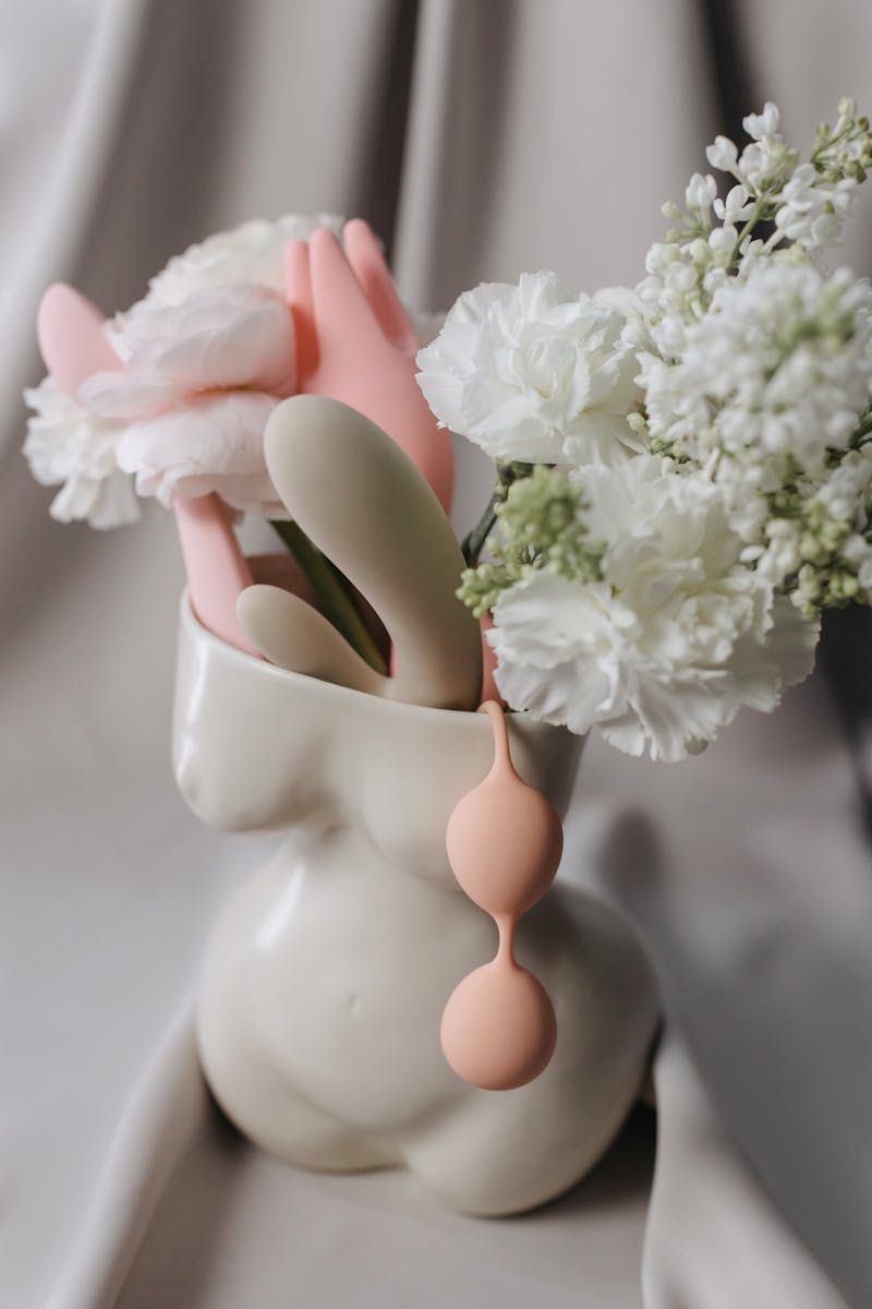Colored Plastic Toys with Flowers in Clay Vase Shaped like Naked Woman